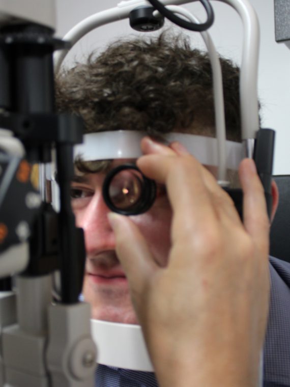 Man having his eyes tested with a Volk lens machine